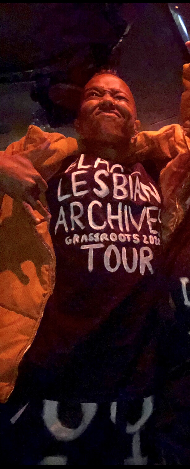 Krü Maekdo wearing t-shirt that says "Black Lesbian Archives Grassroots Tour 20[??]"