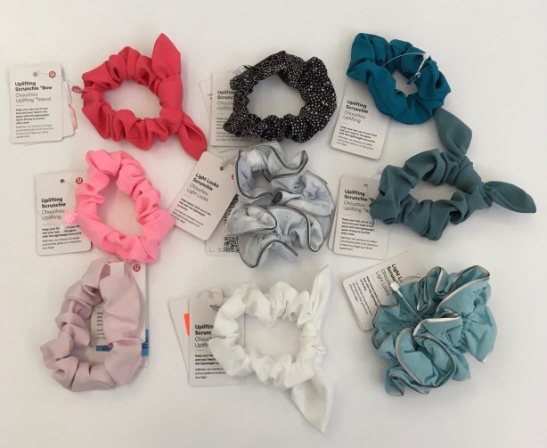 9 scrunchies on display, various colors, w/ exhibit tags.